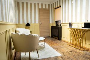 a waiting room with chairs and a table and a desk at La suite Isabelle de Luxembourg in Béthune