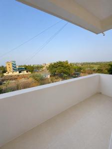 a white balcony with a view of the city at Hotel Shree Jay Amba Deluxe in Jaisingpur