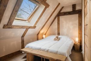 a teddy bear sitting on a bed in a attic at Iaks keramik in Saumont-la-Poterie