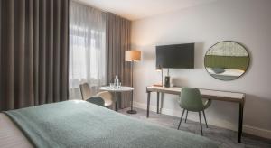 a hotel room with a bed and a desk and a mirror at Hoban Hotel Kilkenny in Kilkenny