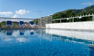 two blue chairs sitting next to a swimming pool at Voilà Beau Vallon in Beau Vallon