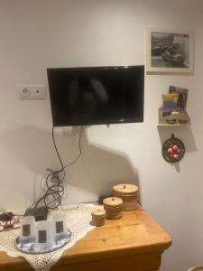 a television hanging on a wall above a table at Au repos du Lezard in Durtal