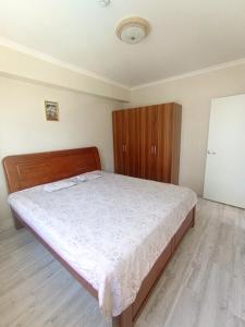 a bedroom with a bed and a wooden cabinet at Darkhan apartment in Darhan