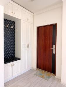 a room with a wooden door and white cabinets at Darkhan apartment in Darhan