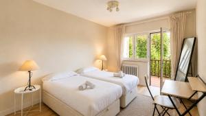 two beds in a room with a window at Villa Toro Playa Llanes a 100 m de la playa in Llanes