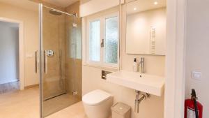 a bathroom with a toilet and a sink and a shower at Villa Toro Playa Llanes a 100 m de la playa in Llanes +29 photos