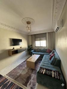 a living room with a couch and a table at Séjour Confort clim Navette Aéroport in Salé