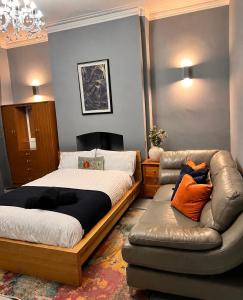 a bedroom with a bed and a leather couch at Ayetonis in Pallion