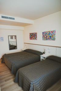 a hotel room with two beds and paintings on the wall at Hotel Magnolia in Preganziol