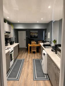 a large kitchen with gray cabinets and a table at Ayetonis in Pallion