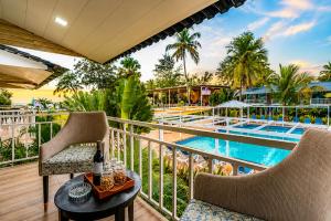 a balcony with chairs and a table and a swimming pool at Foxoso La Beach Resort & Spa in Old Goa