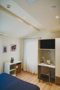 a bedroom with a bed and a desk with a computer at Hotel Magnolia in Preganziol