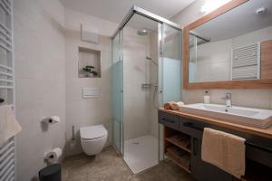 a bathroom with a sink and a toilet and a shower at Gasthof Bergblick in Berwang +69 photos