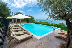 a swimming pool with lounge chairs and an umbrella at The Olive Garden in Shkodër