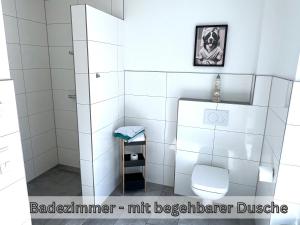 ein Badezimmer mit einer weiß gefliesten Dusche mit Toilette in der Unterkunft "Nemo" Papenburg ebenerdig rollstuhlgerecht 83 qm Neubau EBK 2 Schlafzimmer 4 Personen Free Wifi in Papenburg + 34 Fotos