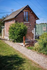 a brick house with a window and a garden at Gîte La Ruchette in Sainte-Marguerite-sur-Duclair