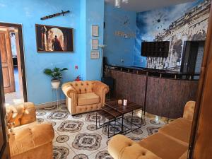 a living room with blue walls and leather furniture at Boutique Hotel Empress in Rožňava