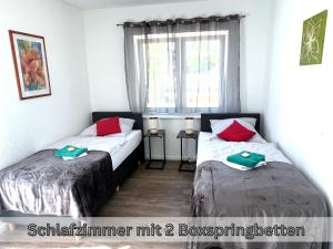 ein Schlafzimmer mit zwei Betten und einem Fenster in der Unterkunft "Nemo" Papenburg ebenerdig rollstuhlgerecht 83 qm Neubau EBK 2 Schlafzimmer 4 Personen Free Wifi in Papenburg
