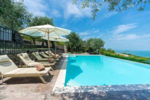 a swimming pool with lounge chairs and an umbrella at The Olive Garden in Shkodër