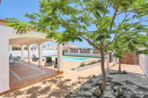 an outdoor patio with a tree and a swimming pool at Refugio del Viento in Antigua