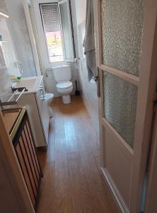 a bathroom with a toilet and a window and a door at Enjoy Pirineos in Huesca