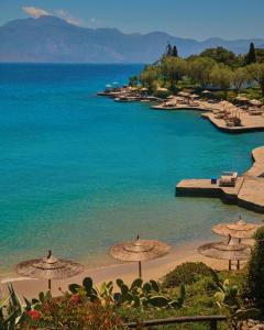 a beach with umbrellas and the ocean at Minos Beach Art Hotel, a Member of Design Hotels in Agios Nikolaos