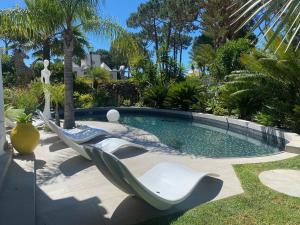 a swimming pool with lounge chairs in a yard at Villa Karolina in Quarteira