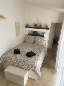 a bedroom with a bed with two black towels on it at Gîte chez l'habitant indépendant "La villa des ocres" in Gargas
