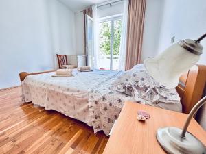 a bedroom with a bed and a table with a lamp at room MLIN 1 in Lun