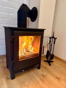 a wood stove with a fire in a room at Wellness Chata Trvalka in Píkovice