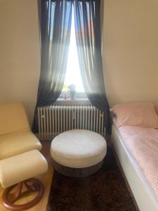 a room with a bed and a stool and a window at Smart in Bad Pyrmont