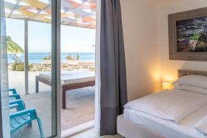 a bedroom with a bed and a balcony with the ocean at Barbara Piran Beach Hotel in Piran +135 photos