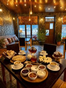 a table with many plates and bowls of food on it at Guest House Nikala in Mestia