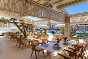 a restaurant with tables and chairs and a view of a harbor at Hotel Adria in Malinska