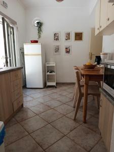 a kitchen with a table and a white refrigerator at Feidiou 1 vol II in Egina +21 photos