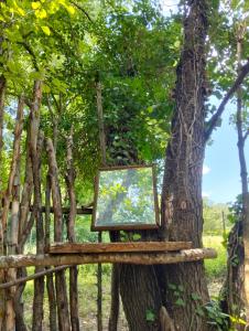 a painting on a wooden stand next to a tree at tente type yourth dans les bois in Saint-Paulet-de-Caisson
