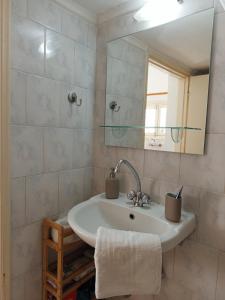 a bathroom with a sink and a mirror at Feidiou 1 vol II in Egina
