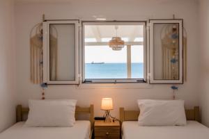 sypialnia z dwoma łóżkami i oknem z widokiem na ocean w obiekcie Sea view Theoni w mieście Katakolo