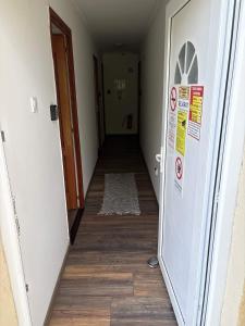 an empty hallway with a door and a rug at Kincső Vendégház Siófok in Siófok