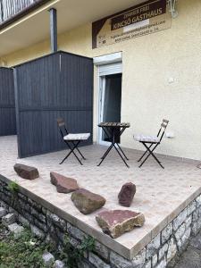 a patio with two chairs and a table and rocks at Kincső Vendégház Siófok in Siófok +142 photos