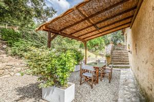 a table and chairs under a wooden pergola at Tenuta della Selva - Castellaccio 7 in Murlo