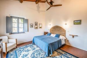 a bedroom with a bed and a chair and a window at Tenuta della Selva - Castellaccio 7 in Murlo