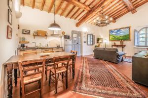 a kitchen and living room with a large wooden table at Tenuta della Selva - Castellaccio 7 in Murlo +3 photos