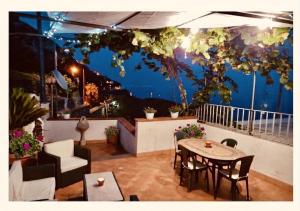 a patio with a table and chairs on a balcony at Il Rifugio Di Ela con 2 appartamenti in Furore