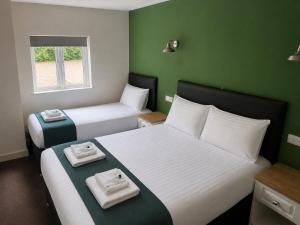 two beds in a small room with green walls at Liberal House Tamworth in Tamworth