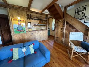 a living room with a blue couch and a chair at Maison Angèle in Saint Nicolas