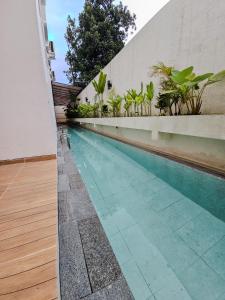 a swimming pool in the side of a building at Lodjisvarga Villa Yogyakarta in Sleman