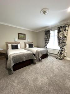 a bedroom with two beds and a window at The Harbour Inn in Buncrana