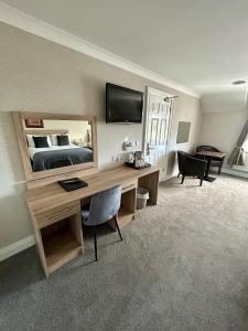 a room with a desk with a bed and a mirror at The Harbour Inn in Buncrana