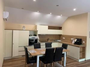a kitchen with a table and chairs in a room at Felüdülő Apartman Balatonlelle in Balatonlelle
